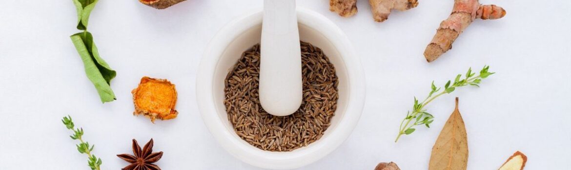 Herbs and spices circling a pestle and morter