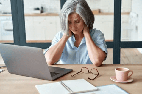 Woman with neck pain at work - fibromyalgia