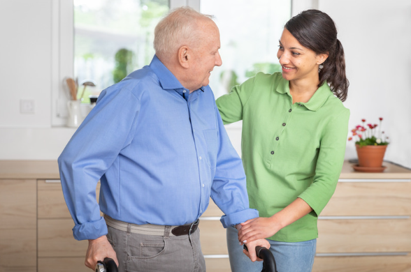 A carer helping an elderly man