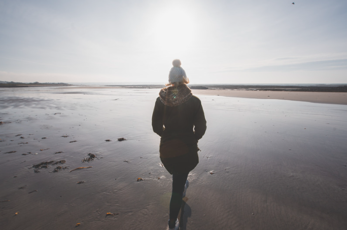 Woman walking on the beach at winter