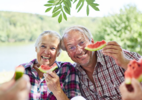 Eldrly couple eating watermelon in the sun