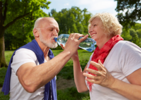 Elderly couple drinking water in the summer sun