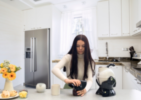 Woman in the kitchen using the Uccello Grip Mat to open a jar lid