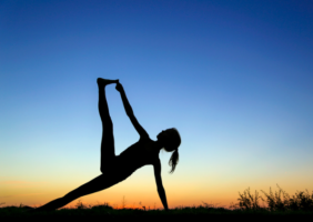 Woman doing yoga at sunrise