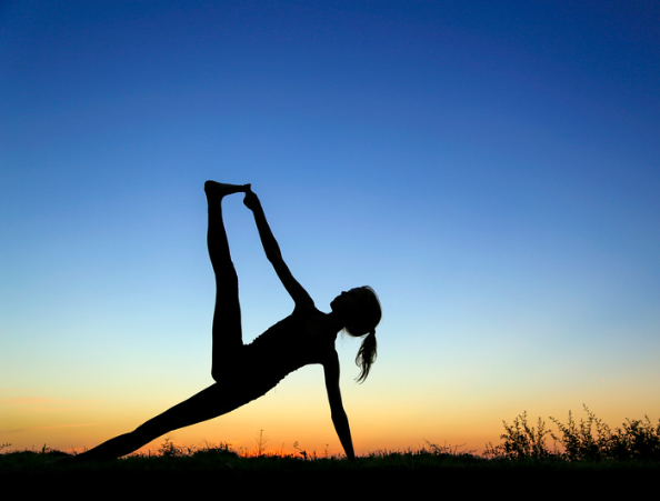 Woman doing yoga at sunrise