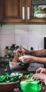 Adult son helping his elderly mother prepare dinner in the kitchen