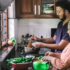 Adult son helping his elderly mother prepare dinner in the kitchen