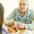 Daughter talking to her elderly mother over tea