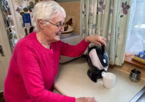 Elderly woman making tea with her tilt-to-pour Uccello Kettle