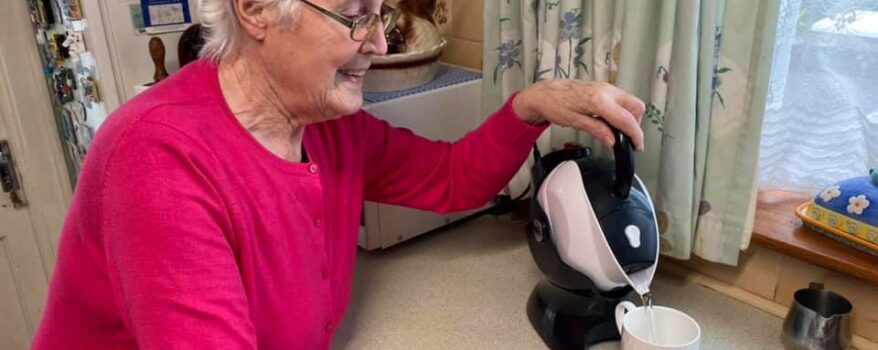 Elderly woman making tea with her tilt-to-pour Uccello Kettle