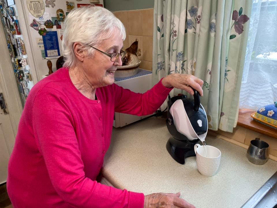 Elderly woman making tea with her tilt-to-pour Uccello Kettle